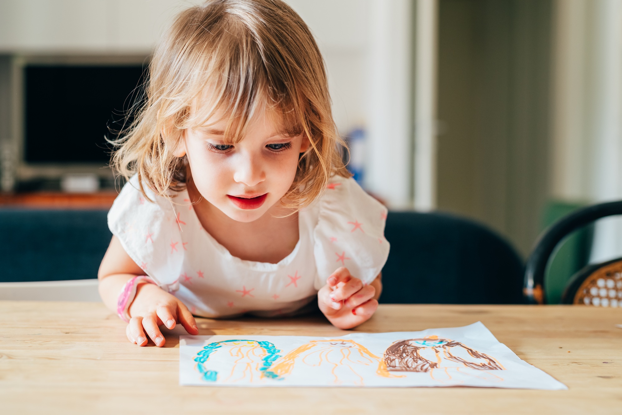 female child indoor drawing on a paper