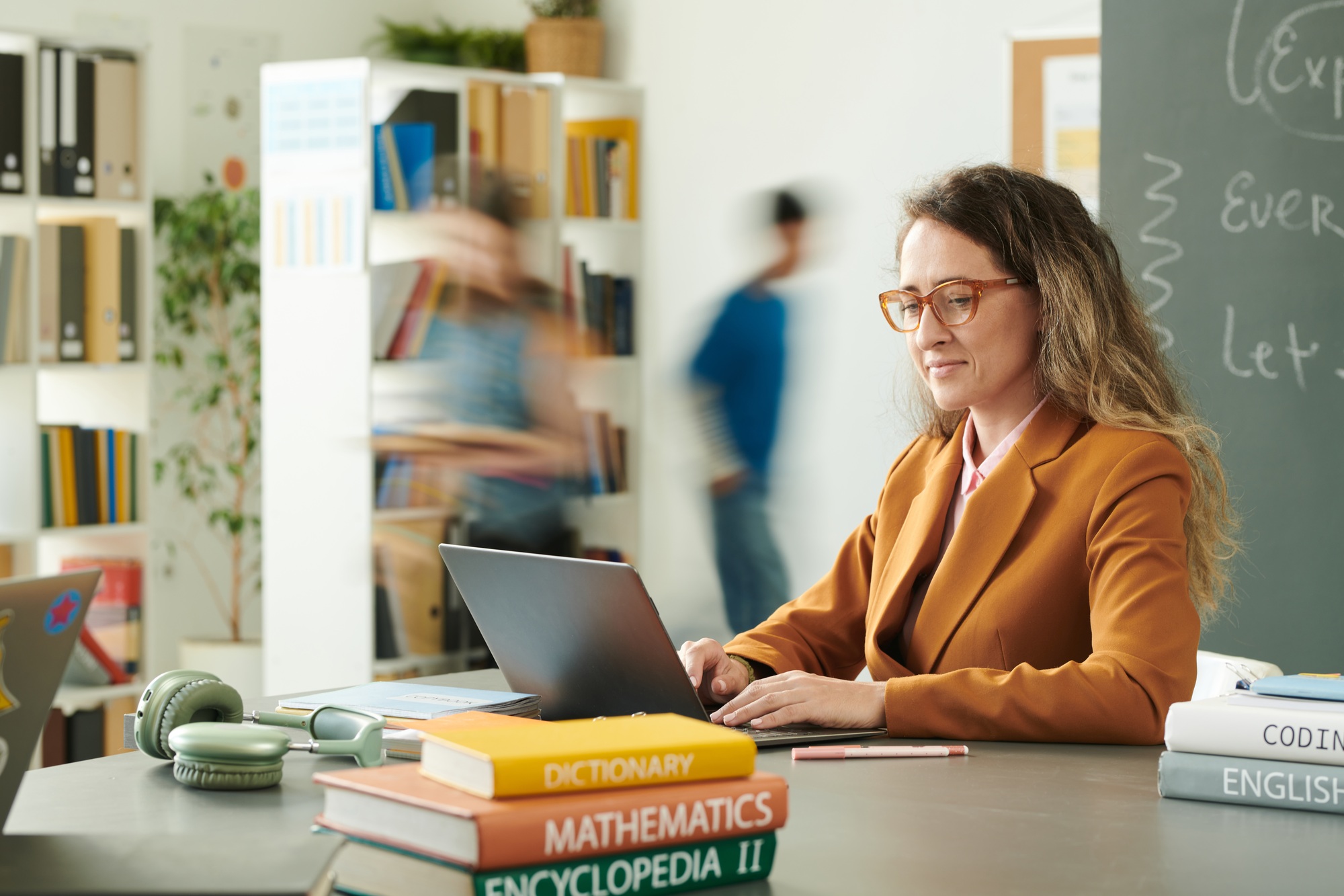 Smiling Female Teacher using Computer