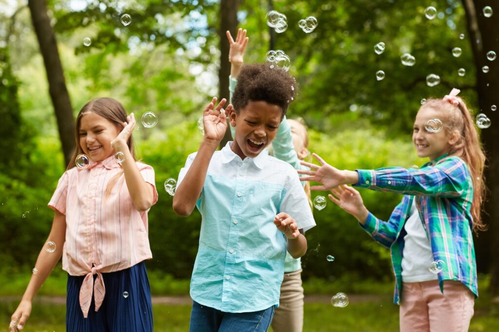 Carefree Children Playing with Bubbles Outdoors