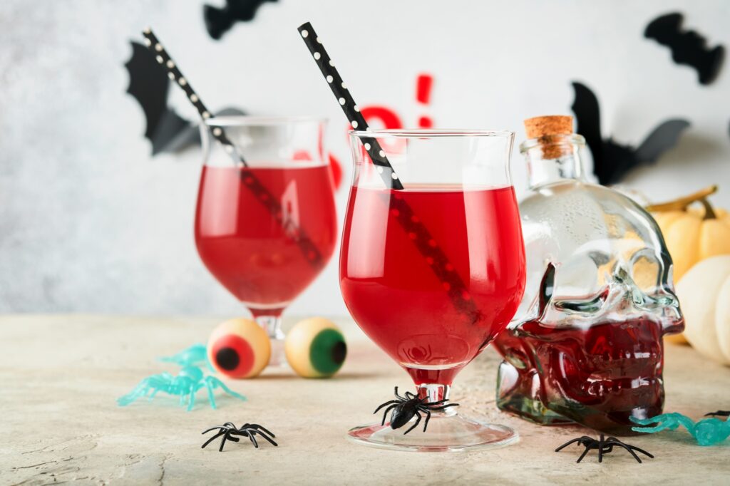Halloween bloody cocktails. Two bloody cocktails glass goblets for Halloween and bottle form skull o