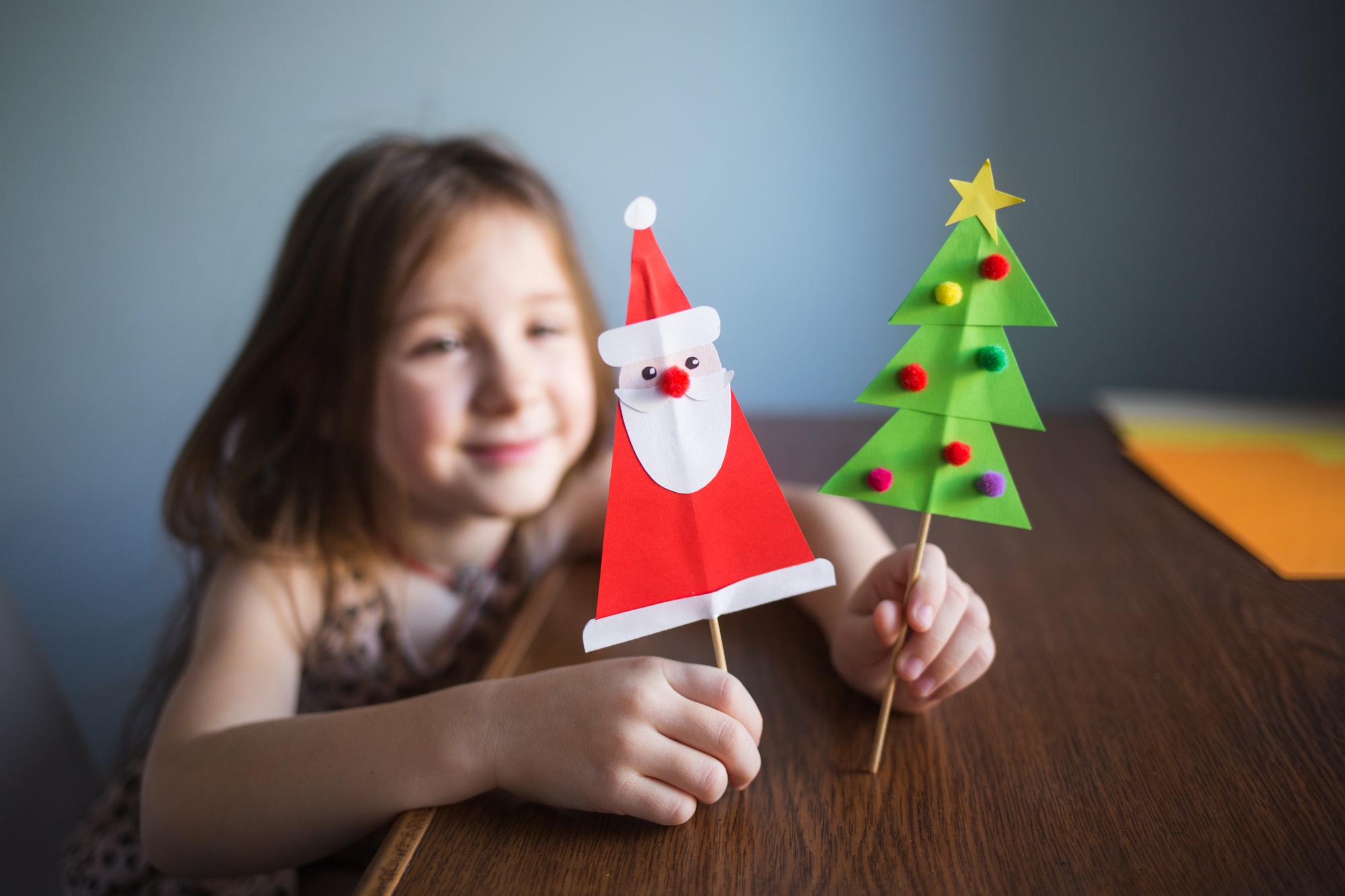 happy girl child sitting at home or in kindergarten at table at home, smiling and playing with
