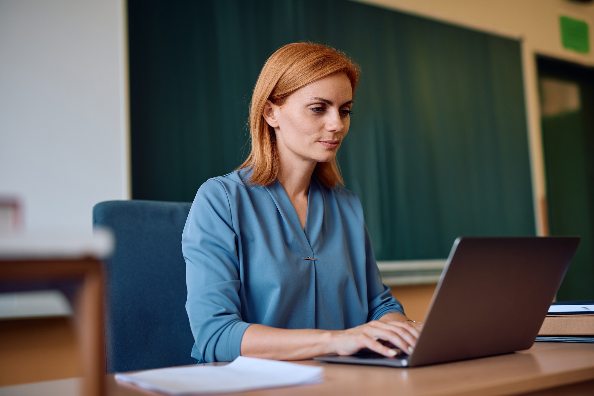 Female teacher using laptop in the classroom.