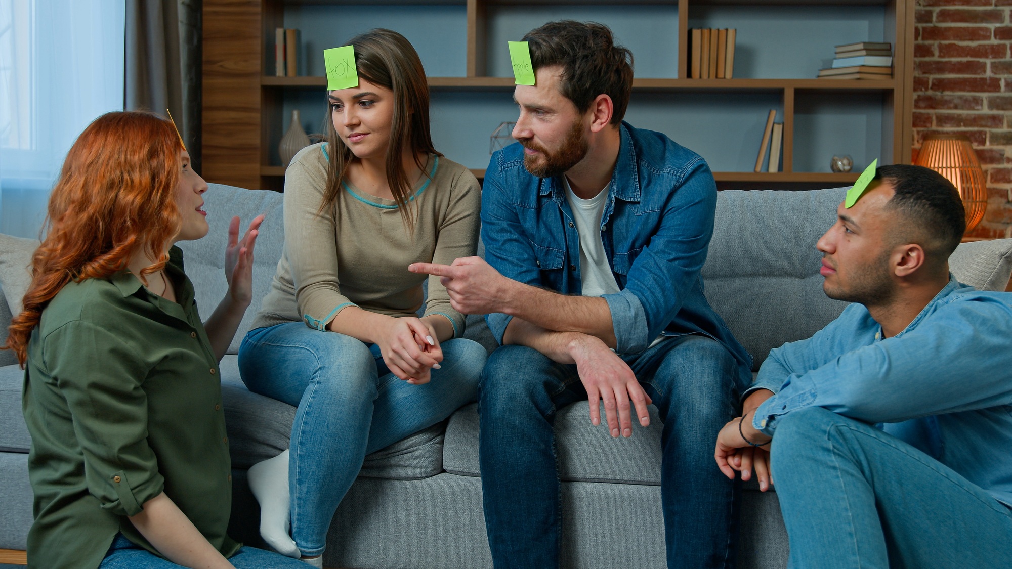Group of multiethnic friends play charades game at home happy laughing diverse ethnic men and women