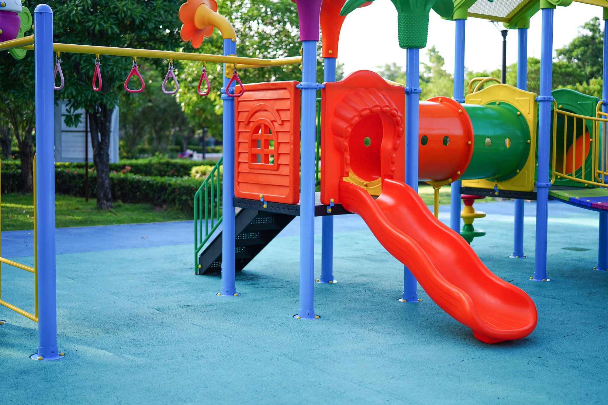 Playground for kid children having fun with colorful slide at yard activities in public park.