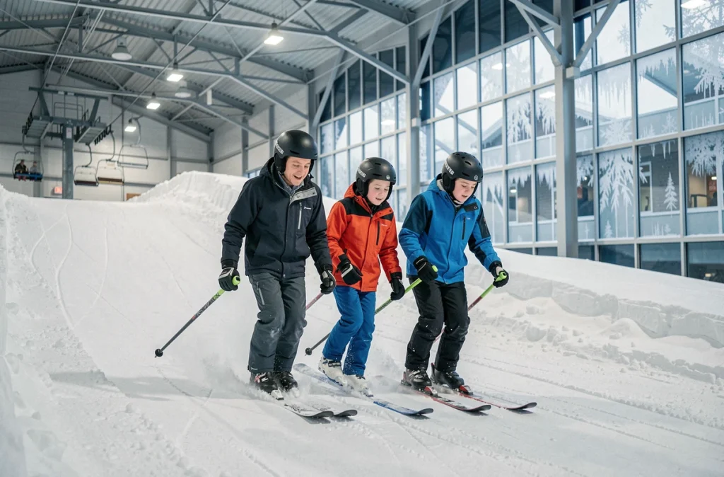 Famille en train de skier sur les pistes enneigées de Snowworld à Amnéville